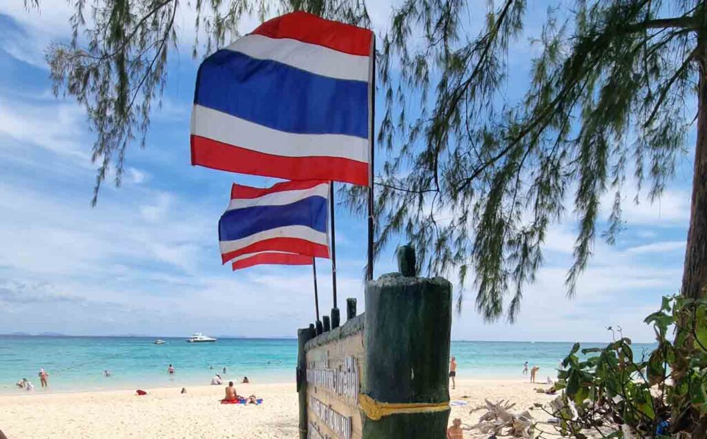 Bandeira da Tailândia e a praia de Bamboo Island durante o passeio TailanDay em Phi Phi, o melhor passeio de barco das ilhas da Tailândia, visitando Maya Bay.